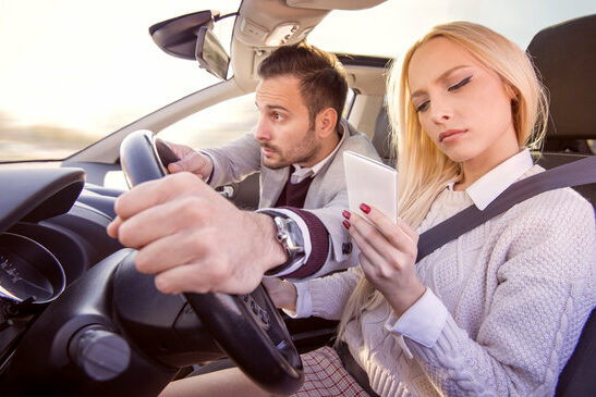Woman typing text message while driving a car
