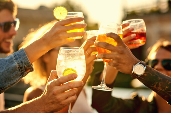 In the end, all that matters is happiness. Cropped shot of a group of unrecognizable friends having a drink and spending the day outside on a rooftop. Friends summer evening downtown parking