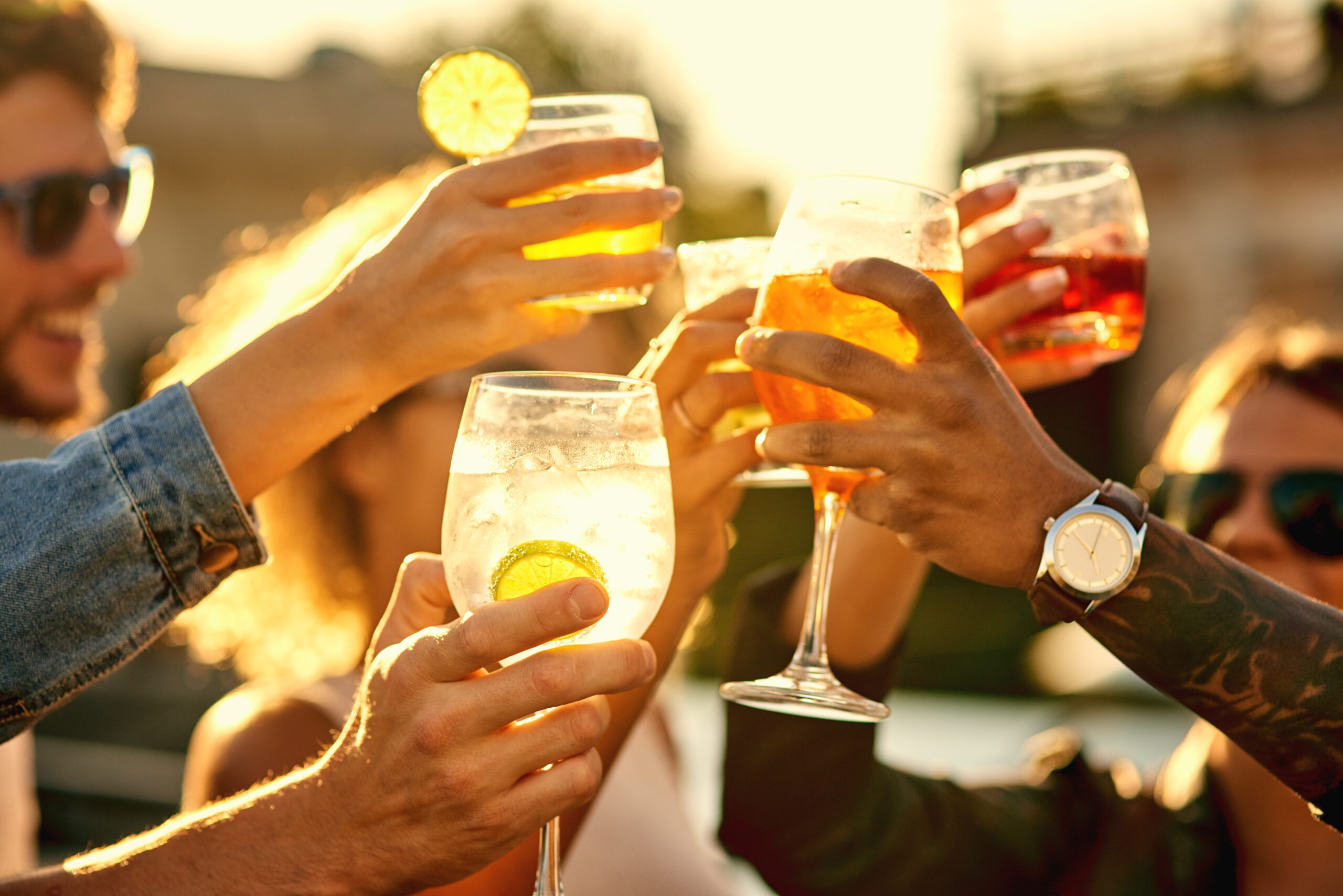 In the end, all that matters is happiness. Cropped shot of a group of unrecognizable friends having a drink and spending the day outside on a rooftop. Friends summer evening downtown parking
